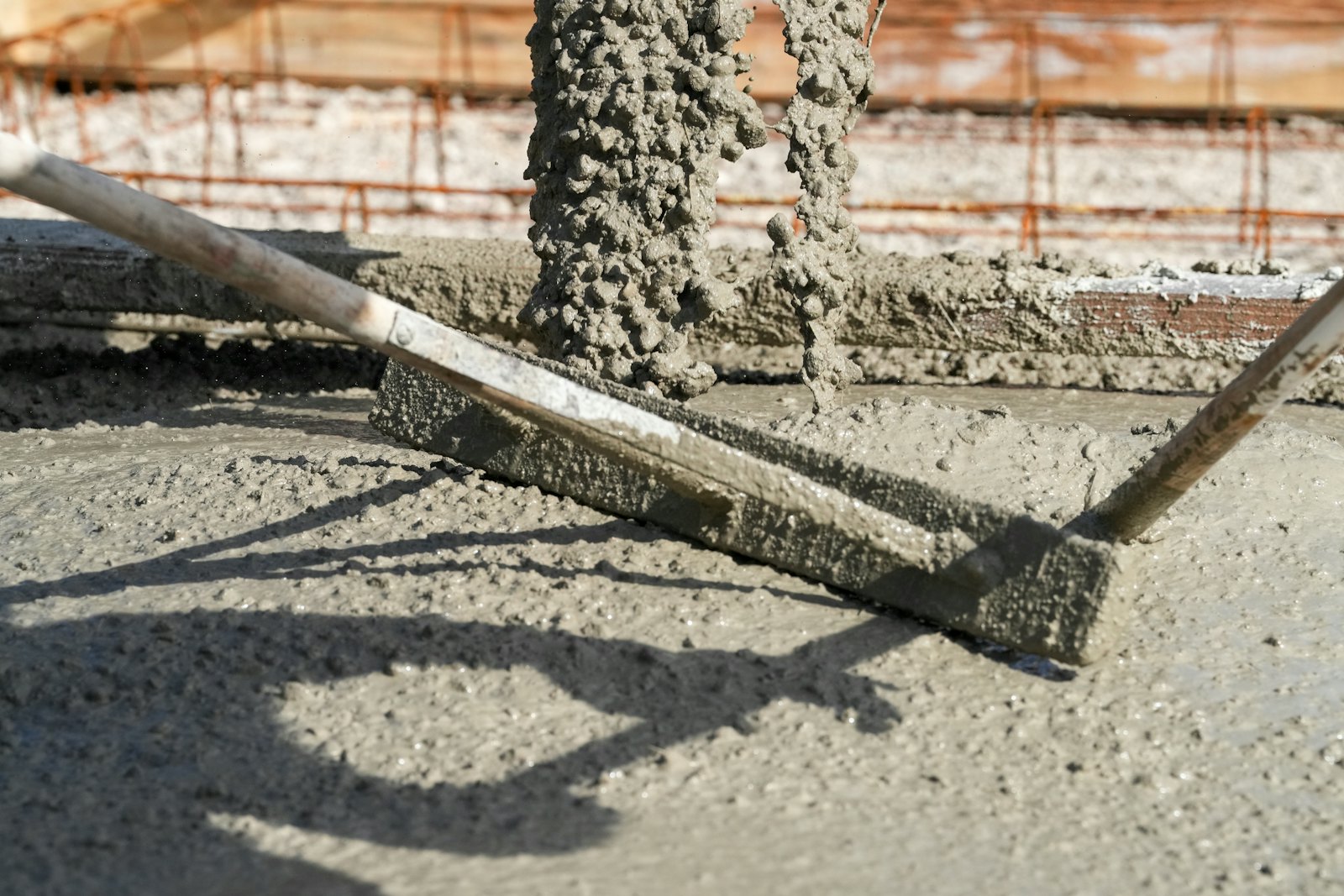 Screed board leveling a fresh concrete pour
