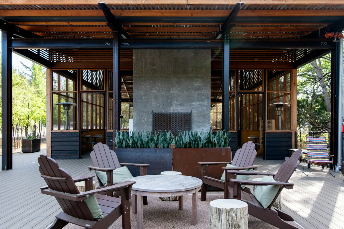 Covered concrete patio with a stone fireplace